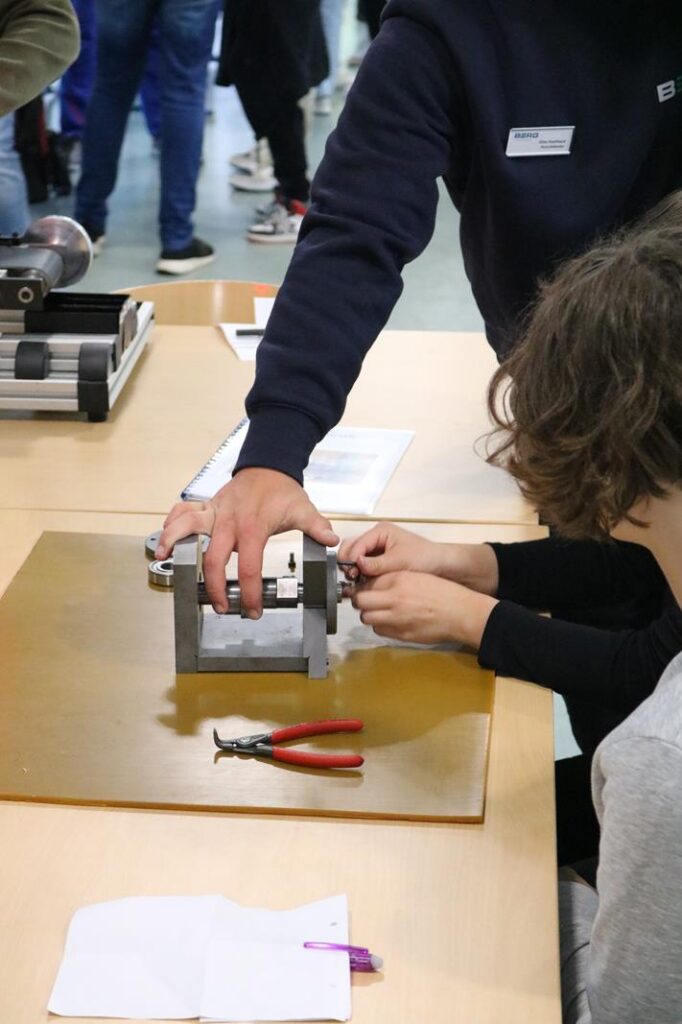 Schüler arbeiten gemeinsam an einem Technikprojekt mit Werkzeugen und Materialien.