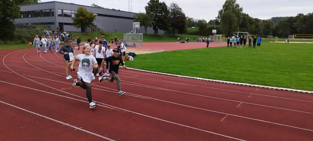 Schüler laufen auf einer Rennbahn während eines Sportevents.