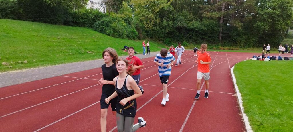 Schüler laufen auf einer Sportbahn während des Trainings.