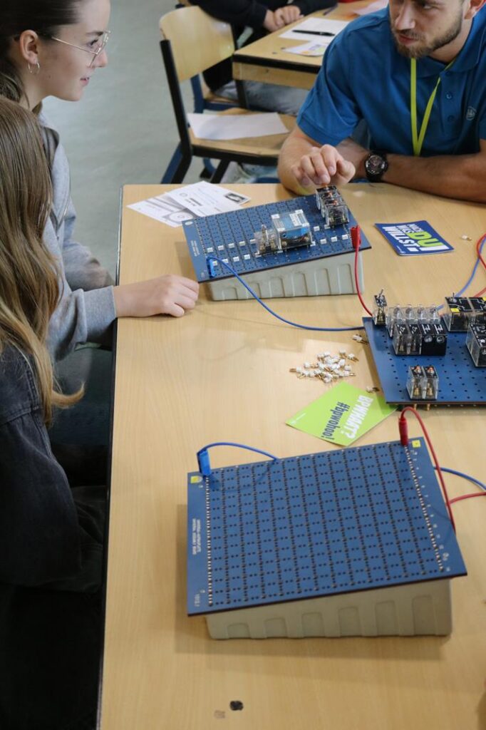 Schüler arbeiten an Gleichstromschaltungen am Tisch mit elektronischen Bauteilen.