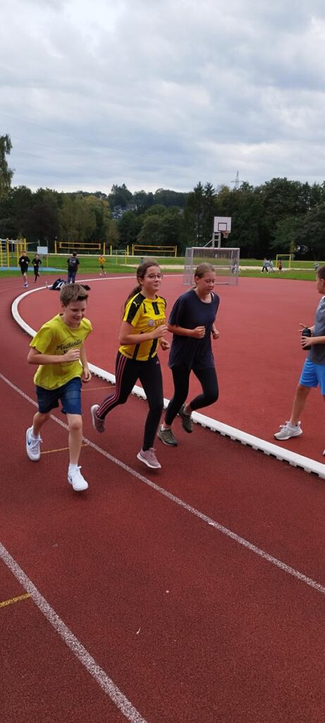 Läufer auf einer Tartanbahn während eines Wettkampfs im Freien.