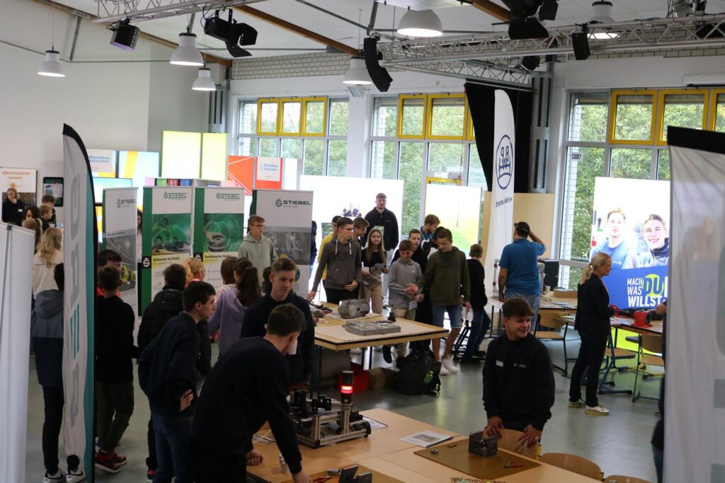 Messeveranstaltung mit zahlreichen Besucherinnen und Besuchern in einem großen Raum.