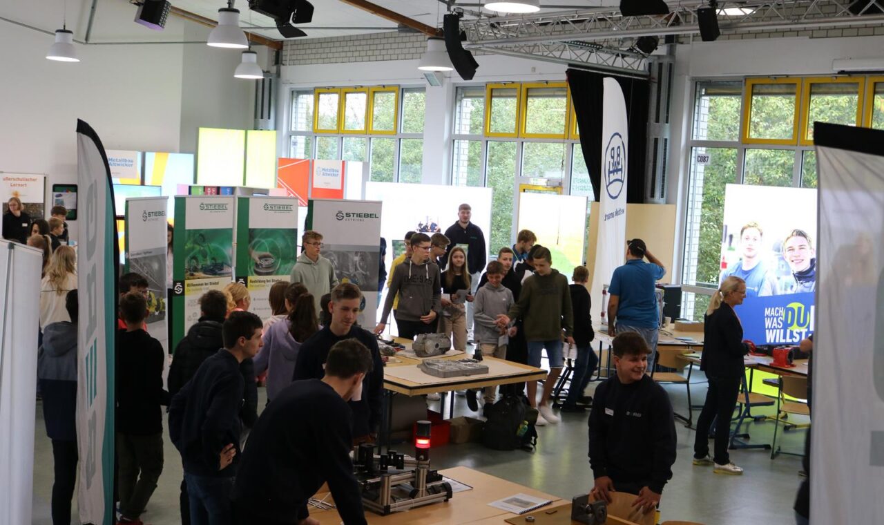 Messeveranstaltung mit zahlreichen Besucherinnen und Besuchern in einem großen Raum.