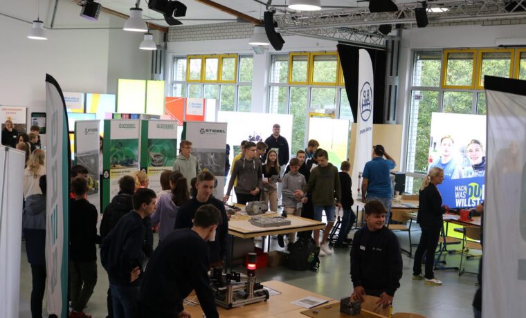 Messeveranstaltung mit zahlreichen Besucherinnen und Besuchern in einem großen Raum.