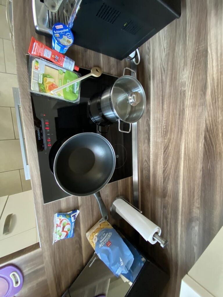 Küchenarbeitsfläche mit Kochgeschirr und Zutaten.