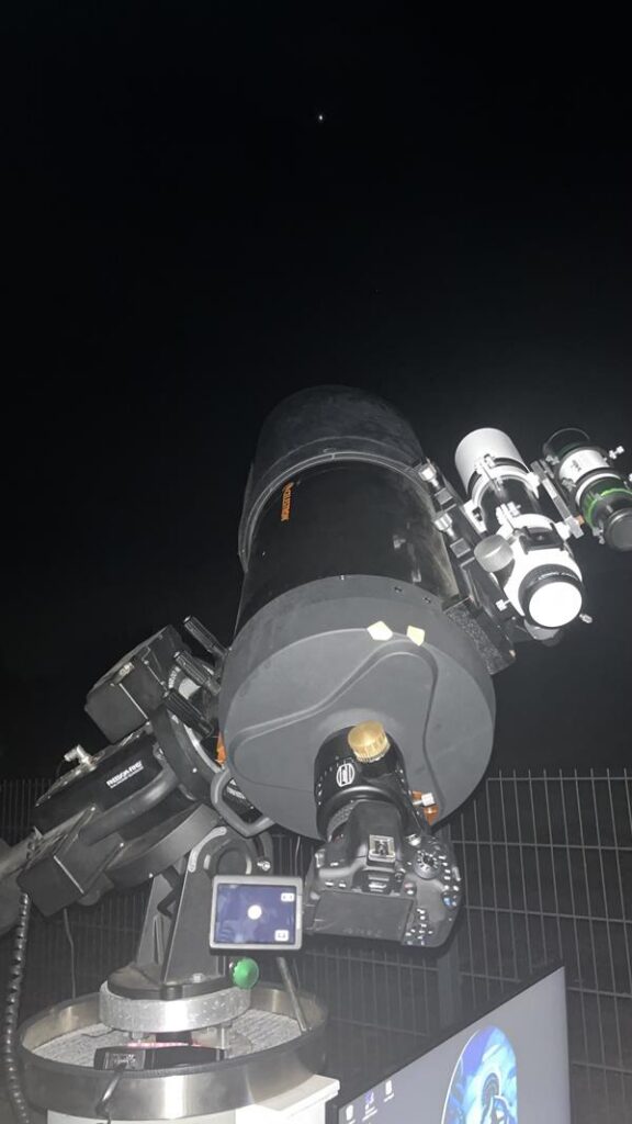 Teleskop auf einem Stativ, gerichtet auf den Nachthimmel.