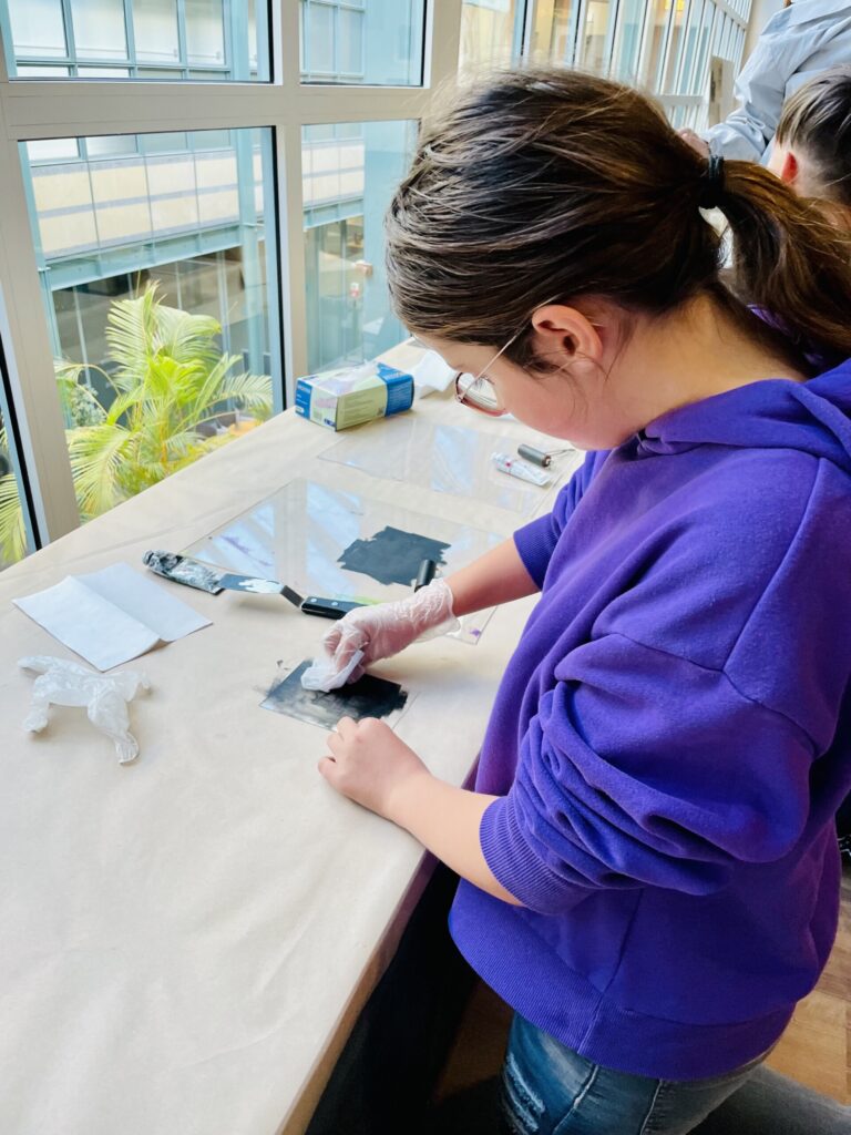 Schülerin arbeitet an einem Tisch mit Materialien und Werkzeugen.