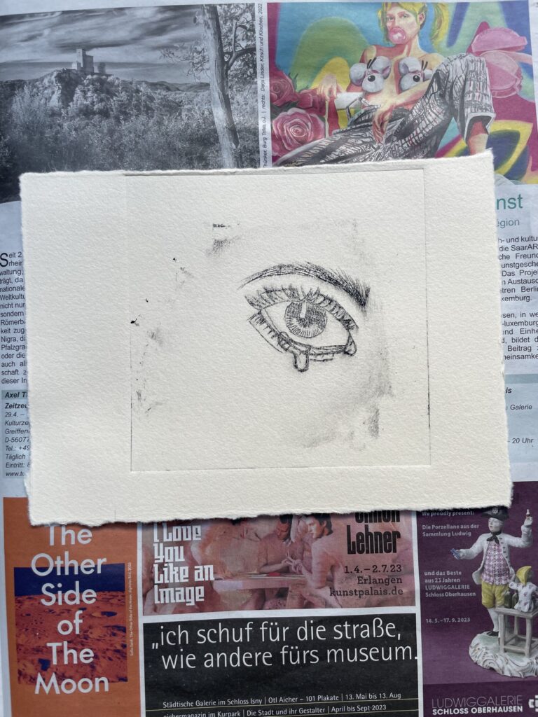 Ein Auge wurde auf ein Blatt Papier gezeichnet, umgeben von verschiedenen Plakaten.