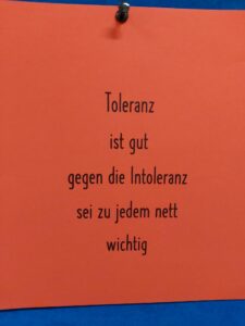 Rotes Plakat mit dem Text über Toleranz und Nettigkeit.