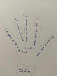 Hand mit Beschriftungen zu Toleranz und Freundschaft.