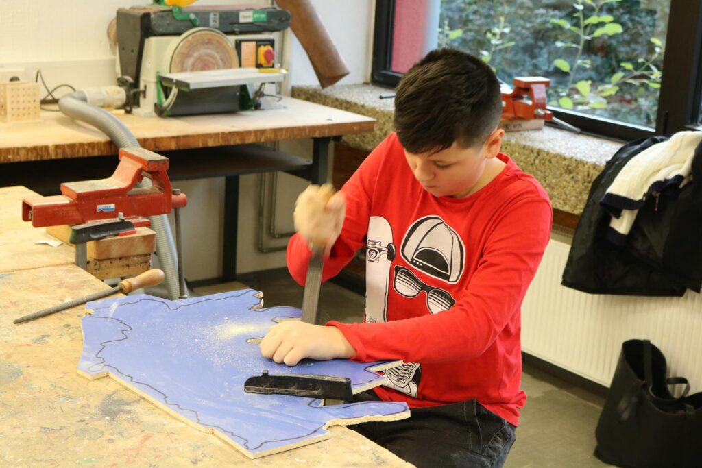 Schüler arbeitet an einem Bastelprojekt in der Werkstatt.