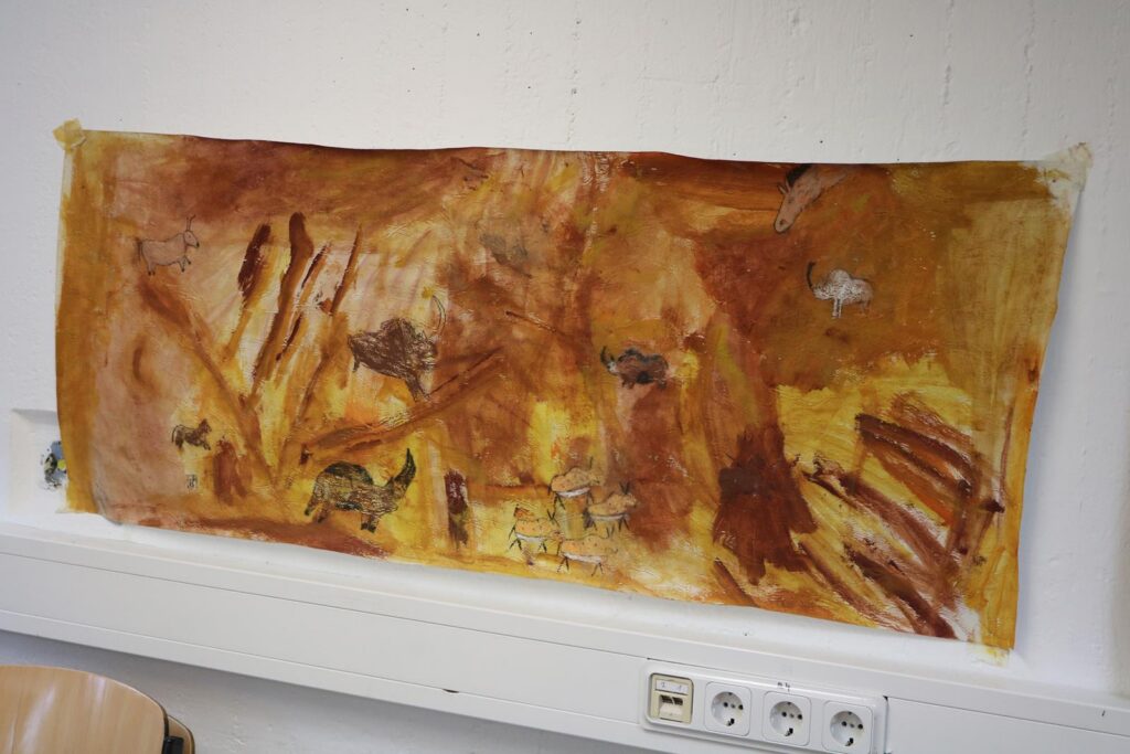 Wandbild mit bunten, erdigen Farbtönen und abstrakten Formen.