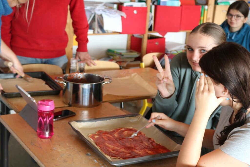 Schülerinnen arbeiten an einem Projekt mit Lebensmitteln in einem Klassenzimmer.