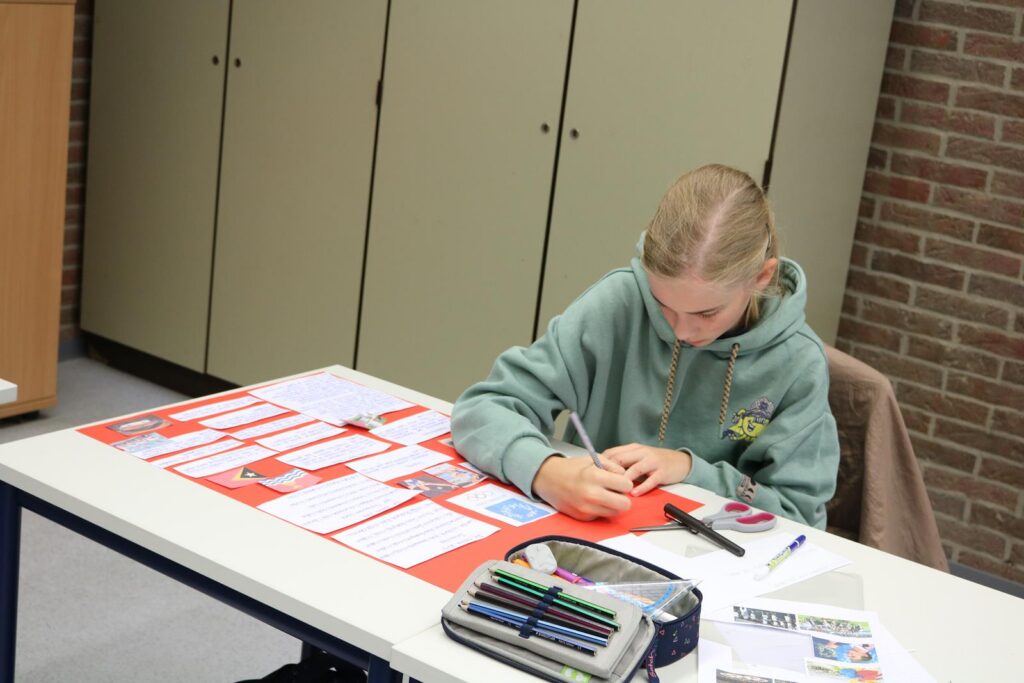 Schülerin arbeitet an einem Projekt an einem Tisch in einem Klassenzimmer.