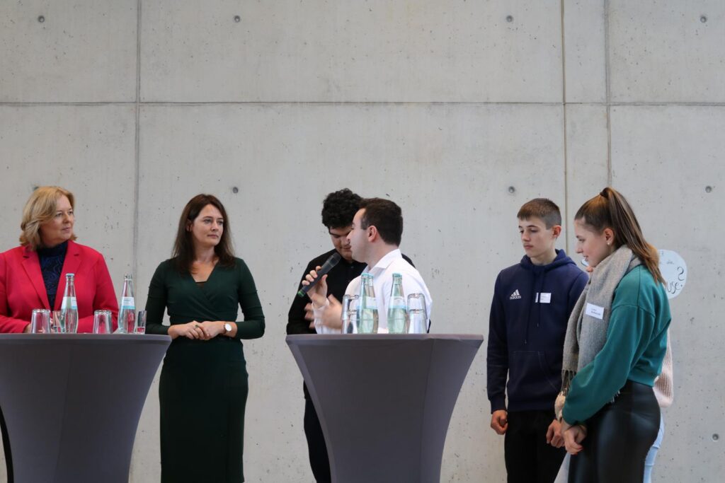 Diskussion an Stehtischen mit mehreren Personen in einem modernen Raum.