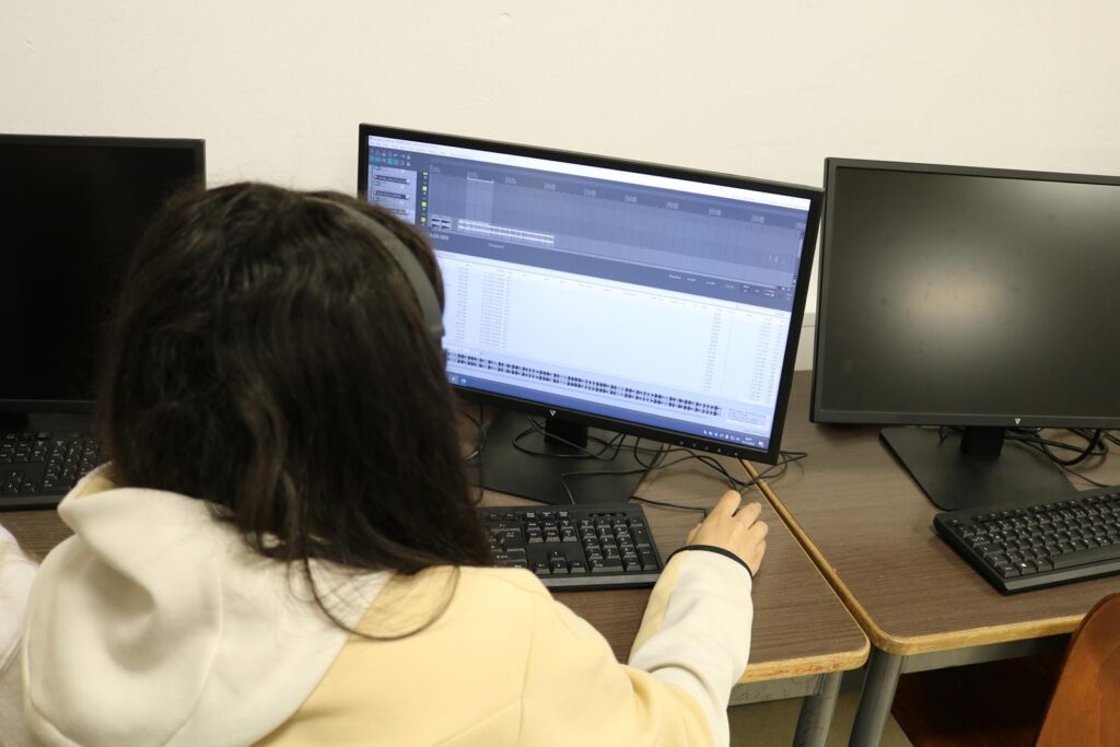 Schülerin arbeitet an einem Computer in einem Klassenraum.