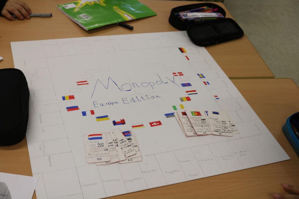 Großes Plakat mit dem Titel "Monopoly" und vielen Flaggen.