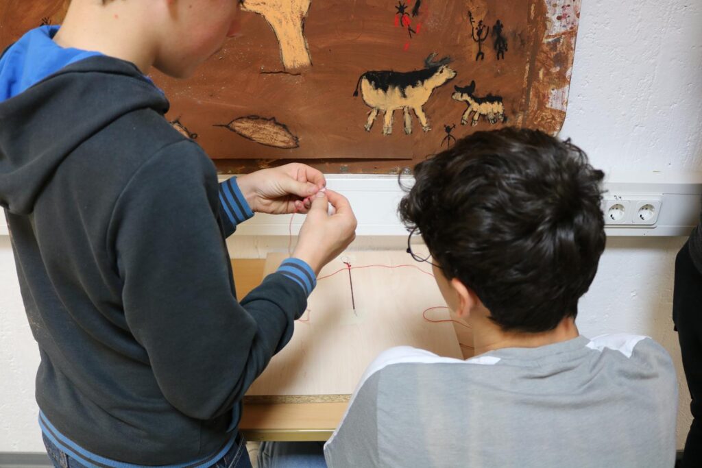 Zwei Schüler arbeiten zusammen an einem Bastelprojekt.