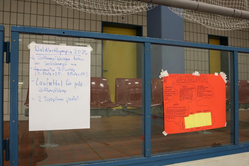Informationstafeln in einem Schulgebäude, beschriftet mit Texten und Hinweisen.