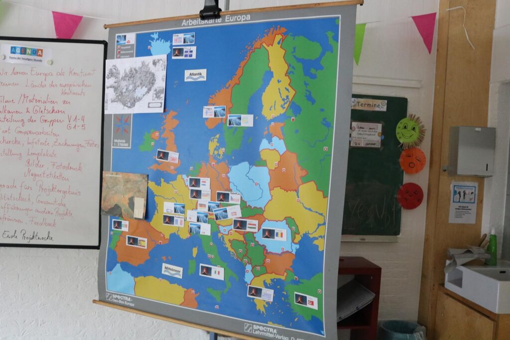 Eine bunte Europakarte mit markierten Ländern und Flaggen an einer Wand.