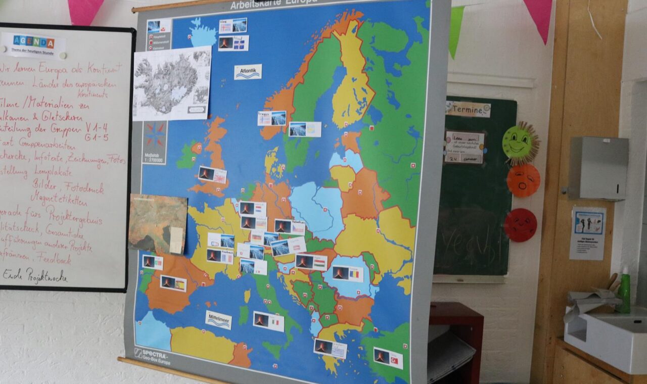 Eine bunte Europakarte mit markierten Ländern und Flaggen an einer Wand.