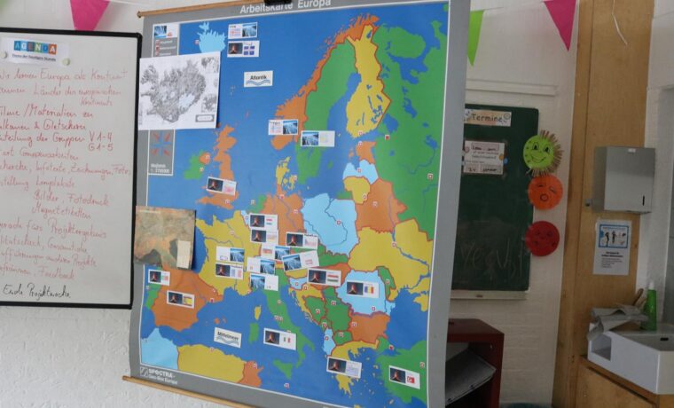Eine bunte Europakarte mit markierten Ländern und Flaggen an einer Wand.