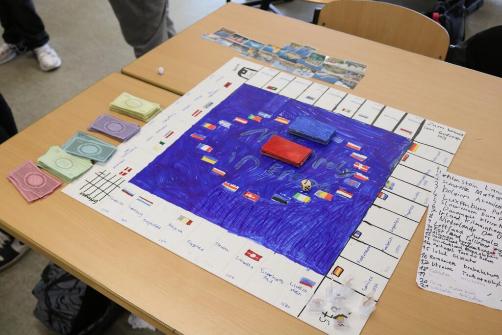 Brettspiel auf einem Tisch mit Geldscheinen und Spielkarten.