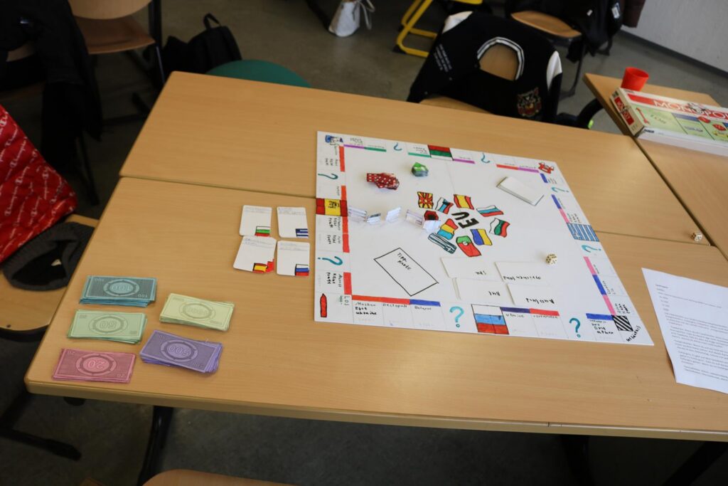 Ein Tisch mit einem Monopoly-Spiel, Geld und Spielkarten liegen daneben.