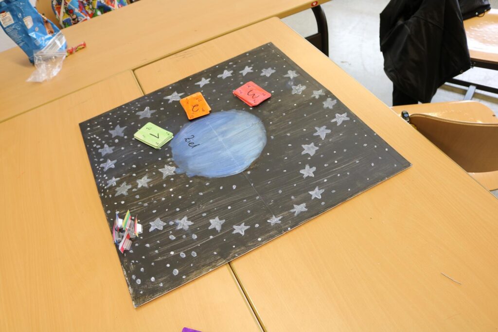 Ein Plakat mit einem Mond und Sternen auf einem Tisch in einem Klassenzimmer.