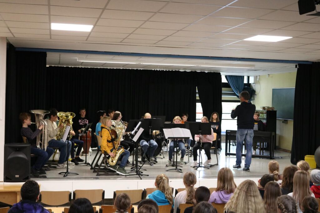 Schüler spielen in einer Schulaufführung Musik auf der Bühne.
