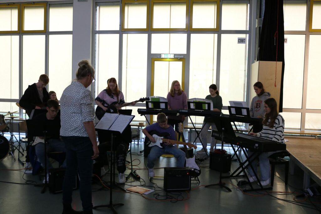 Schüler spielen gemeinsam Instrumente in einem Musikraum.