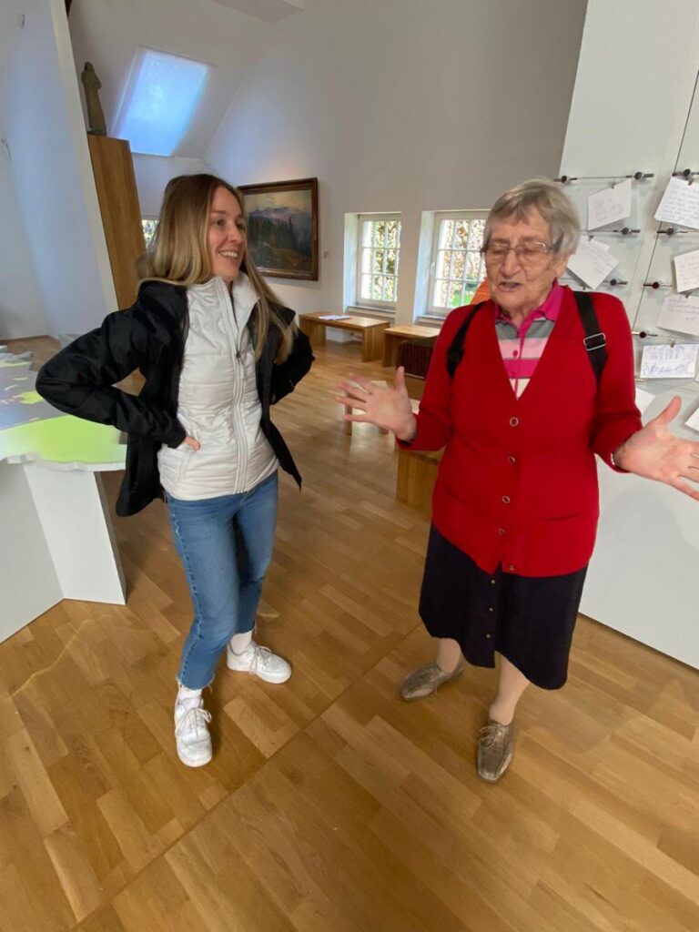 Zwei Frauen unterhalten sich in einem Ausstellungsraum.