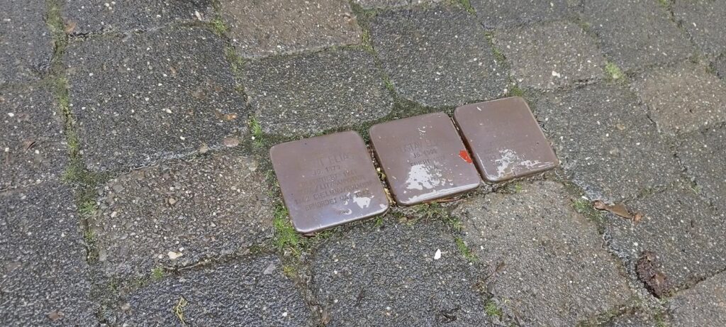 Drei quadratische Platten auf einem gepflasterten Gehweg.