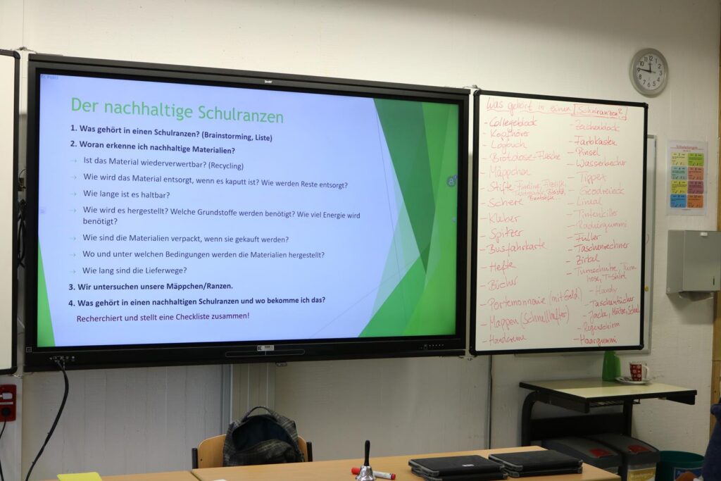 Präsentationstafel mit Informationen über nachhaltige Schulen und einer Flipchart.