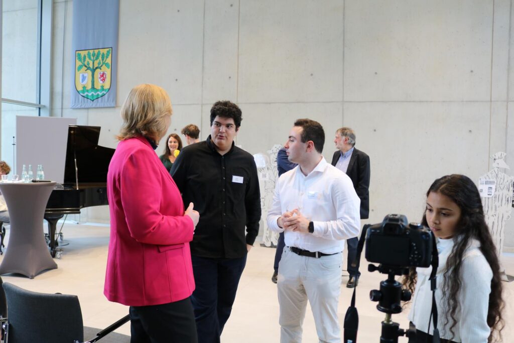 Menschen stehen in einem modernen Raum und unterhalten sich.