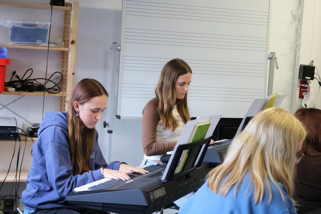 Schülerinnen üben am Keyboard in einem Musikraum.