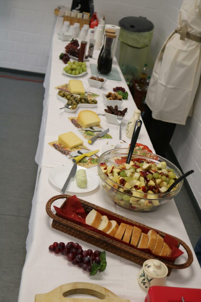 Ein reichhaltiges Buffet mit verschiedenen Käsesorten, Obst, Gemüse und Getränken.