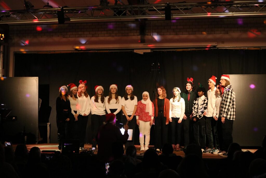 Schüler stehen auf der Bühne und präsentieren ein Weihnachtssingen.
