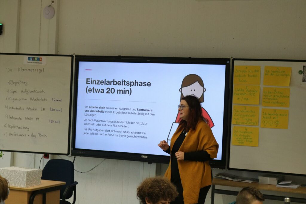 Lehrerin erklärt die Einzelarbeitsphase vor einer Präsentation in der Klasse.