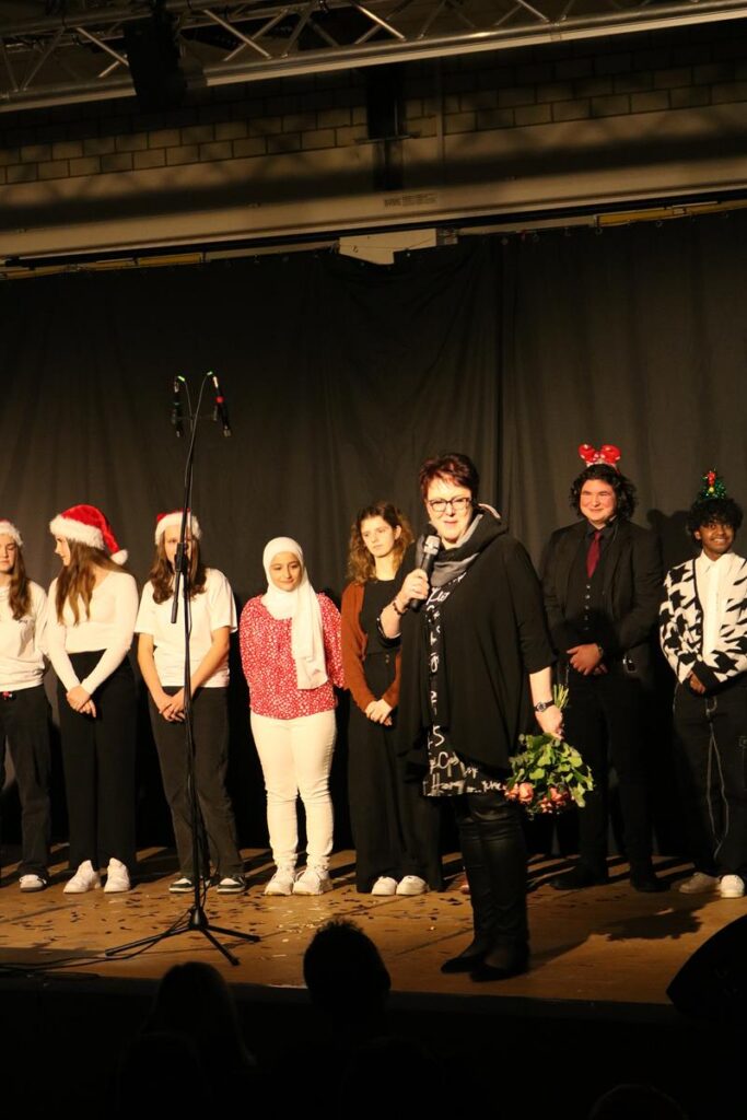 Schüler auf der Bühne bei einer Weihnachtsaufführung mit Mikrofon.