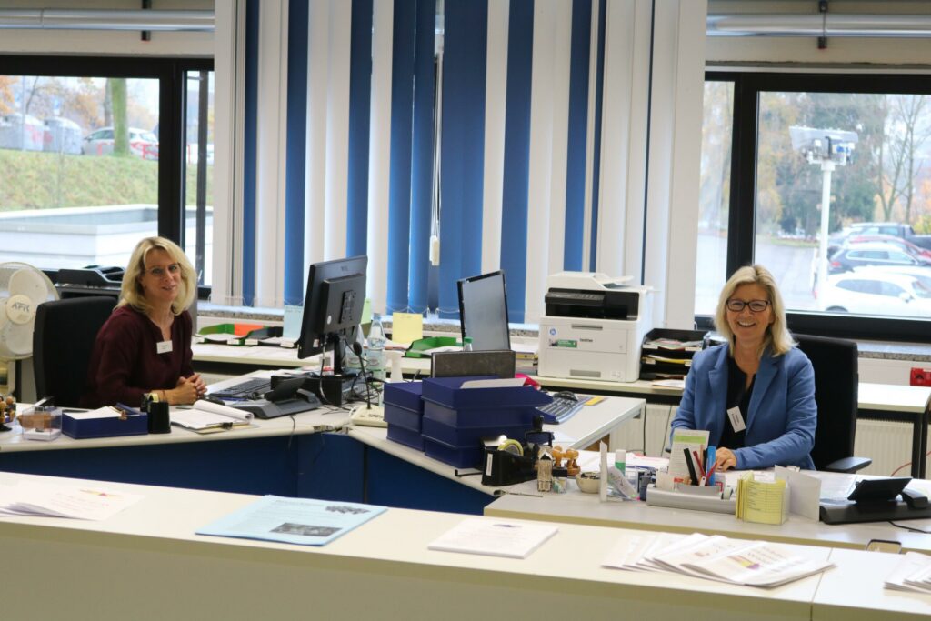 Zwei Frauen an einem Schreibtisch in einem modernen Büro.