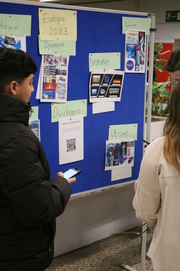 Schüler betrachten Informationen an einem Informationsboard.