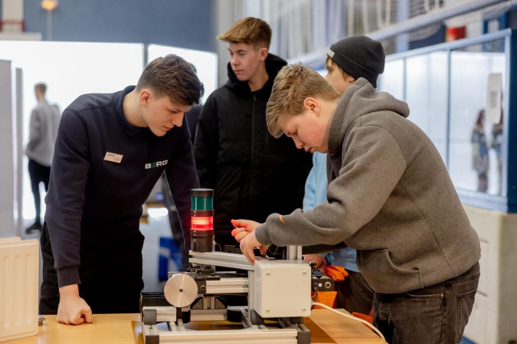 Schüler arbeiten an einem technischen Gerät in einer Schulumgebung.