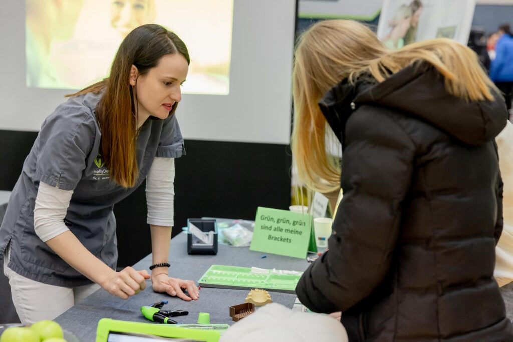 Eine Person informiert eine andere an einem Messestand.