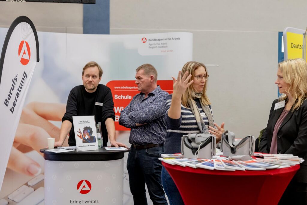 Messestand mit Fachkräften, Informationsmaterialien und Gesprächen.