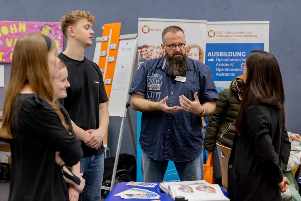 Menschen im Gespräch an einem Informationsstand für Ausbildung.