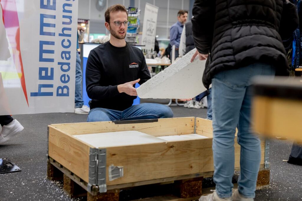 Ein Mann sitzt auf dem Boden und hält ein Plakat in der Hand.