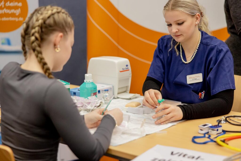 Zwei Schülerinnen arbeiten an einem Tisch mit medizinischem Equipment.