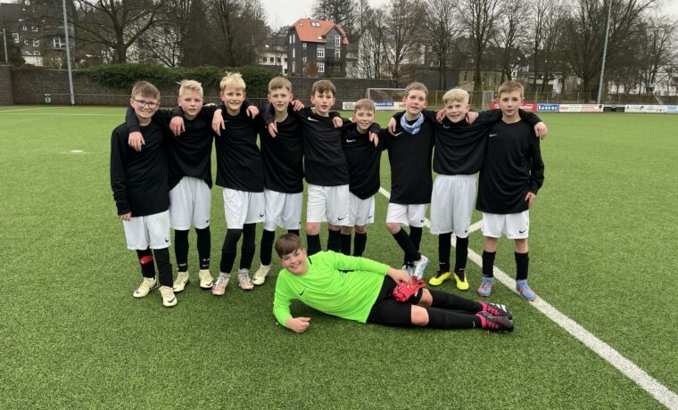 Eine Fußballmannschaft steht auf dem Platz, ein Spieler liegt im Vordergrund.
