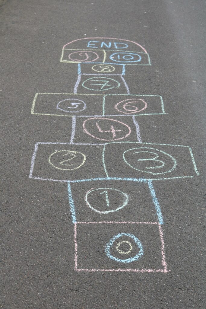 Hüpfenspiel mit bunten Kästchen auf dem Asphalt.